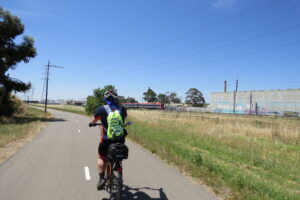 Passing through the Wingfield industrial area. Train from Gawler can be seen in distance [2023]