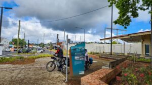 Trail sign in Lilydale with elevated Metro station in background [2022]